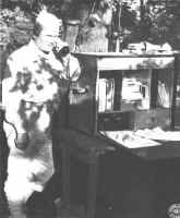 Major General Frank W. Milburn, USA, Hoosier-born commander of the 83rd Infantry Division, the first division ever to train on Hoosier soil, uses a field telephone of the Army Signal Corps during maneuvers at Camp Attrbury early in June.  These field telephones usually are tied into Indiana Bell circuits during field exercises on the reservation.  Speaking for the 83rd Division, Lt. Col. W. G. Belser, Jr., adjutant general, recently declared, "We have found the telephone service here (at Camp Atterbury) to be very excellent."  Take a bow, folks !!  Col. Belser is speaking in behalf of the men we want most to serve efficiently and adequately.